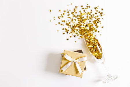 Christmas or new year background with gift boxes and glass of golden glitters, abstract celebration concept. flat lat arrangement with copy space.の写真素材