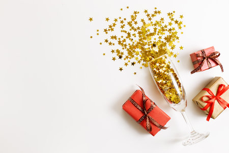 Christmas or new year background with gift boxes and glass of golden glitters, abstract celebration concept. flat lat arrangement with copy space.の写真素材