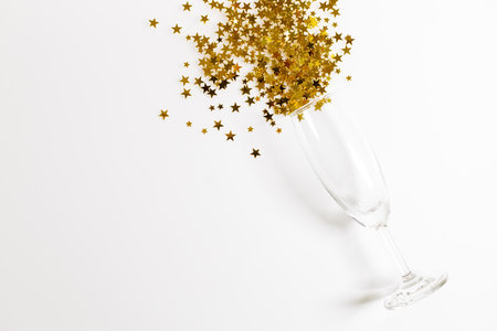 Christmas or new year background with glass of golden glitters, abstract celebration concept. flat lat arrangement with copy space.の写真素材