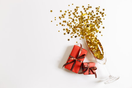 Christmas or new year background with gift boxes and glass of golden glitters, abstract celebration concept. flat lat arrangement with copy space.の写真素材