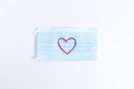 Surgical face masks with handwriting heart shaped, showing love, gratitude and appreciation, top view.の写真素材