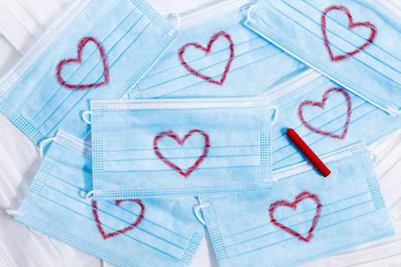 Surgical face masks with handwriting heart shaped, showing love, gratitude and appreciation, top view.の写真素材