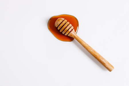 Fresh honey with bamboo dipper on white background