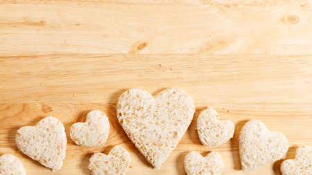 wholewheat bread cut into heart shape on wooden background, top viewの写真素材