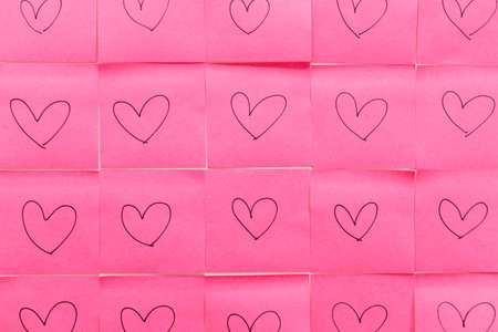 Pink sticky note with heart shaped handwriting on other pink sticky note background.の写真素材