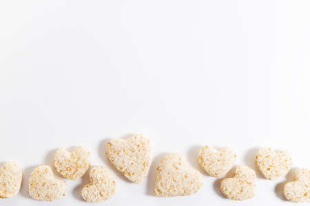 wholewheat bread cut into heart shape on white background, top viewの写真素材