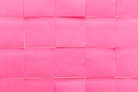 Sticky note in pink color as background, top viewの写真素材