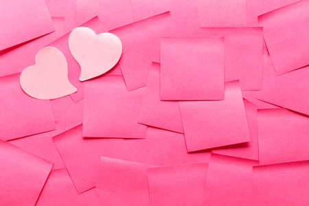 heart shaped pink sticky notes with on other pink sticky note background.の写真素材