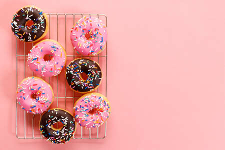 donuts with chocolate frosted, pink glazed and sprinkles on pink background.の写真素材