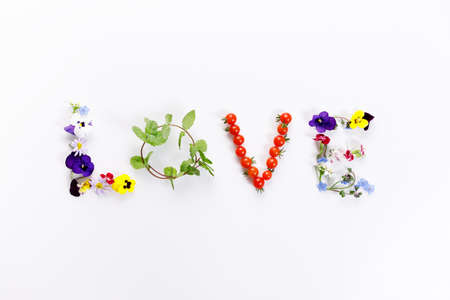 Word "LOVE" made of flowers and leaves on white background. Spring concept. Top view.の写真素材
