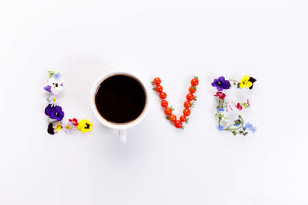 Word "LOVE" made of flowers, coffee and edible things on white background. Spring concept. Top view.の写真素材