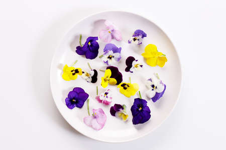 Edible Flowers in a white plate on white background. Healthy organic food.の写真素材