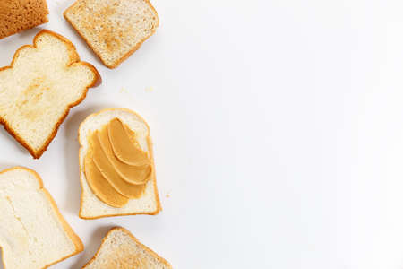 Sliced bread with peanut butter on white background from top view.の写真素材