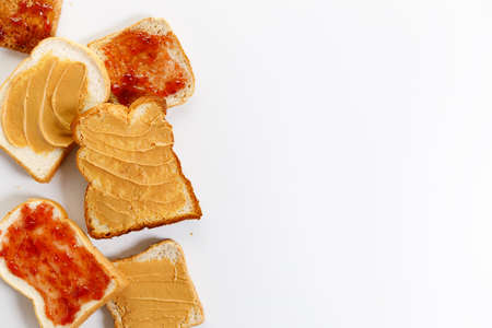 Sliced bread with peanut butter and jam on white background from top view.の写真素材