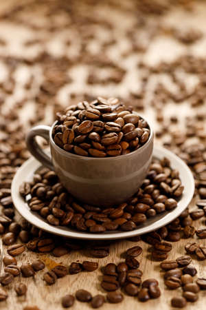 coffee beans roasted in a coffee cup on coffee beans background, closeupの写真素材