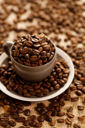 coffee beans roasted in a coffee cup on coffee beans background, closeupの写真素材