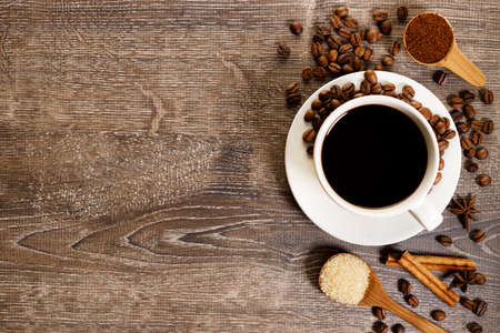 Cup of black coffee with coffee beans on wooden table.の写真素材