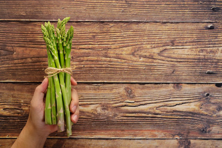 Bunch of fresh green asparagus in handの写真素材