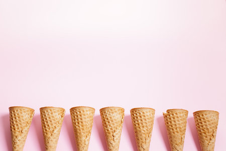 Empty ice cream cones on pink background. Sweet and summer concept. Top view.の写真素材