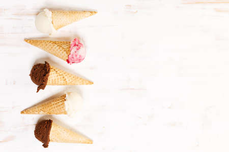 Waffle ice cream cones on with ice cream on white wooden background. Sweet and summer concept.の写真素材