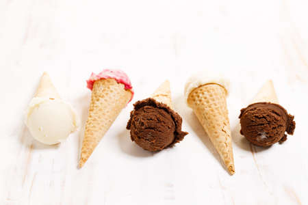 Waffle ice cream cones on with ice cream on white wooden background. Sweet and summer concept.の写真素材