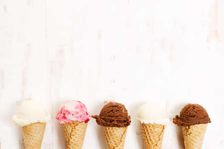 Waffle ice cream cones on with ice cream on white wooden background. Sweet and summer concept.の写真素材