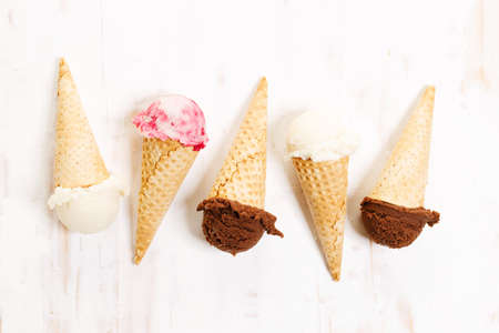 Waffle ice cream cones on with ice cream on white wooden background. Sweet and summer concept.の写真素材