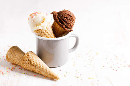 Waffle ice cream cones on with ice cream on white wooden background. Sweet and summer concept.の写真素材