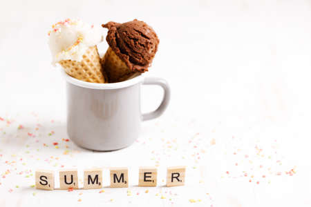 Waffle ice cream cones on with ice cream on white wooden background. Sweet and summer concept.の写真素材