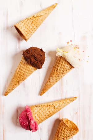 Waffle ice cream cones on with ice cream on white wooden background. Sweet and summer concept.の写真素材