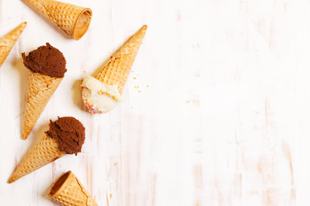 Waffle ice cream cones on with ice cream on white wooden background. Sweet and summer concept.の写真素材