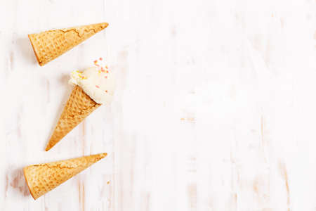 Waffle ice cream cones on with ice cream on white wooden background. Sweet and summer concept.の写真素材