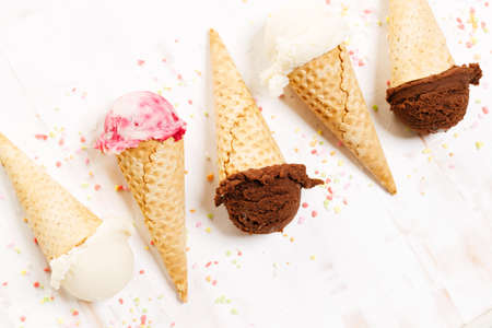 Waffle ice cream cones on with ice cream on white wooden background. Sweet and summer concept.の写真素材