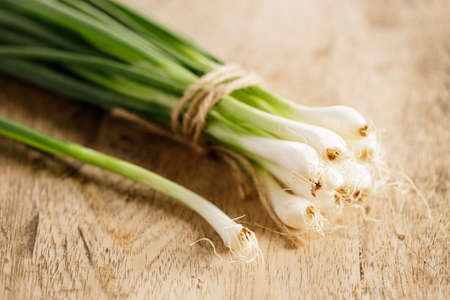 freshness spring green onions on wooden background, closeup.の写真素材