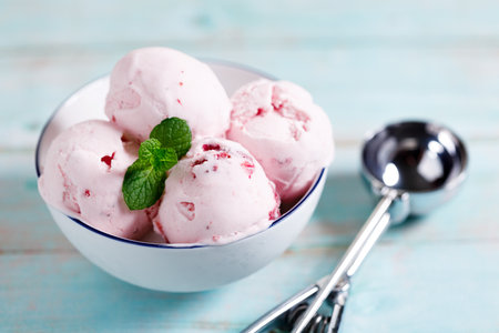 Ice cream scoops in white bowl on wooden table background, closeupの写真素材
