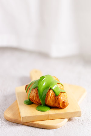 freshly baked sweet croissant decorated with green tea cream, closeup.の写真素材