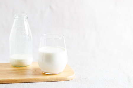 glass of milk and bottle of milk on wooden plate.の写真素材