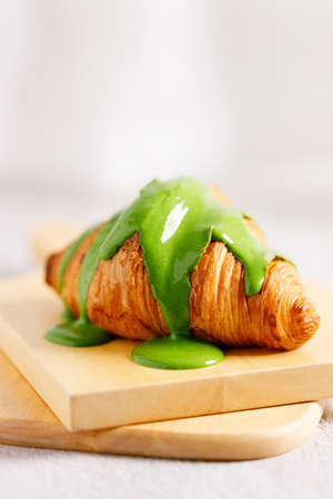 freshly baked sweet croissant decorated with green tea cream, closeup.の写真素材