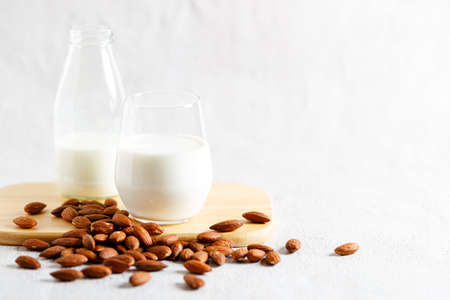 glass of almond milk and bottle. vegan plant based milk and ingredients, copy space.の写真素材