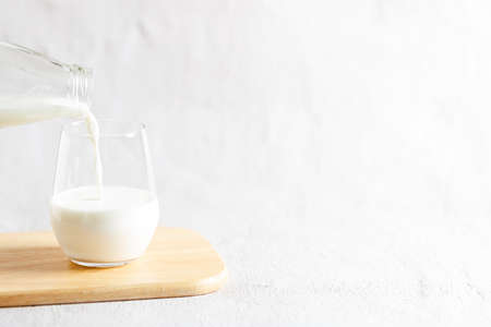 glass of milk and bottle of milk on wooden plate.の写真素材