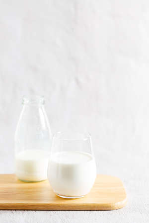 glass of milk and bottle of milk on wooden plate.の写真素材