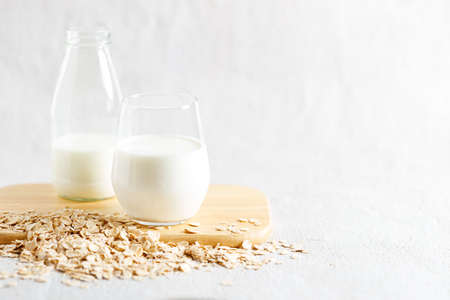 glass of oat milk and bottle. vegan plant based milk and ingredients, copy space.の写真素材
