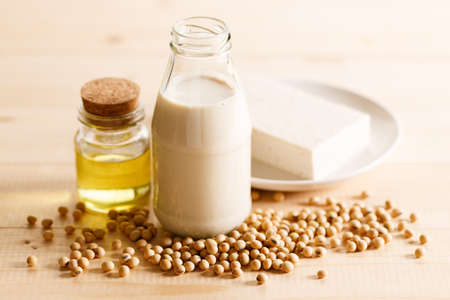 soy milk in a bottle with soybean on wooden background. vegan plant based milk and ingredients,の写真素材