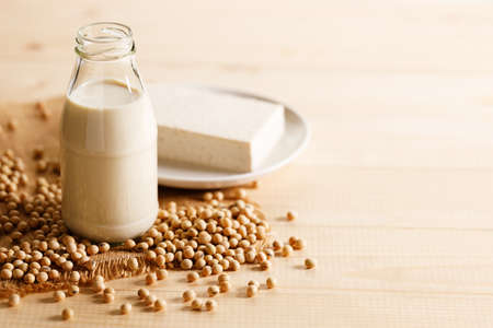 soy milk in a bottle with soybean on wooden background. vegan plant based milk and ingredients,の写真素材