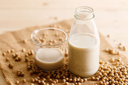 soy milk in a bottle with soybean on wooden background. vegan plant based milk and ingredients,の写真素材