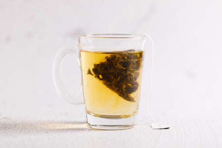 A cup of tea with tea bag on white marble background.の写真素材