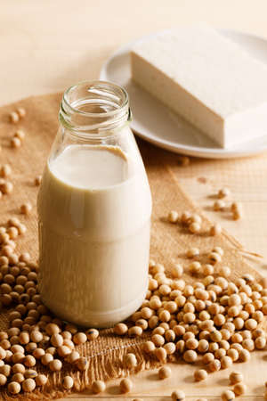 soy milk in a bottle with soybean on wooden background. vegan plant based milk and ingredients,の写真素材