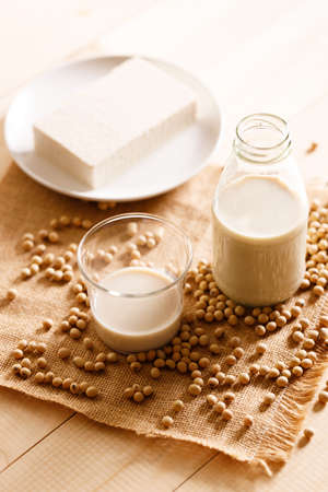 soy milk in a bottle with soybean on wooden background. vegan plant based milk and ingredients,の写真素材