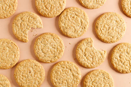 Oatmeal cookie on orange color background. Healthy round cookies. Top view.の写真素材