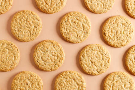 Oatmeal cookie on orange color background. Healthy round cookies. Top view.の写真素材